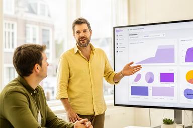 Productleider bespreekt een interactief dashboard in een lichte Amsterdamse werkruimte